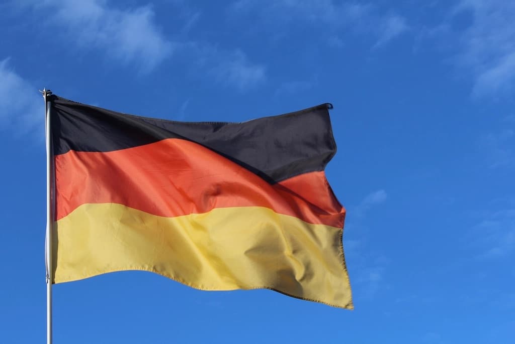 Die deutsche Flagge weht vor blauem Himmel