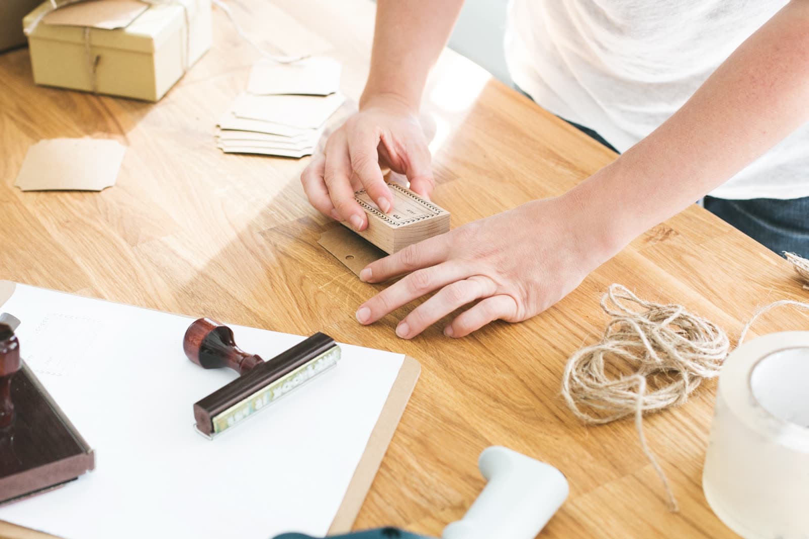 Hände setzen einen Stempel auf einem Holztisch mit Papieren