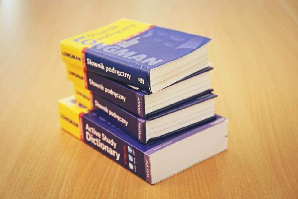 Stapel aus Wörterbüchern auf einem Holztisch