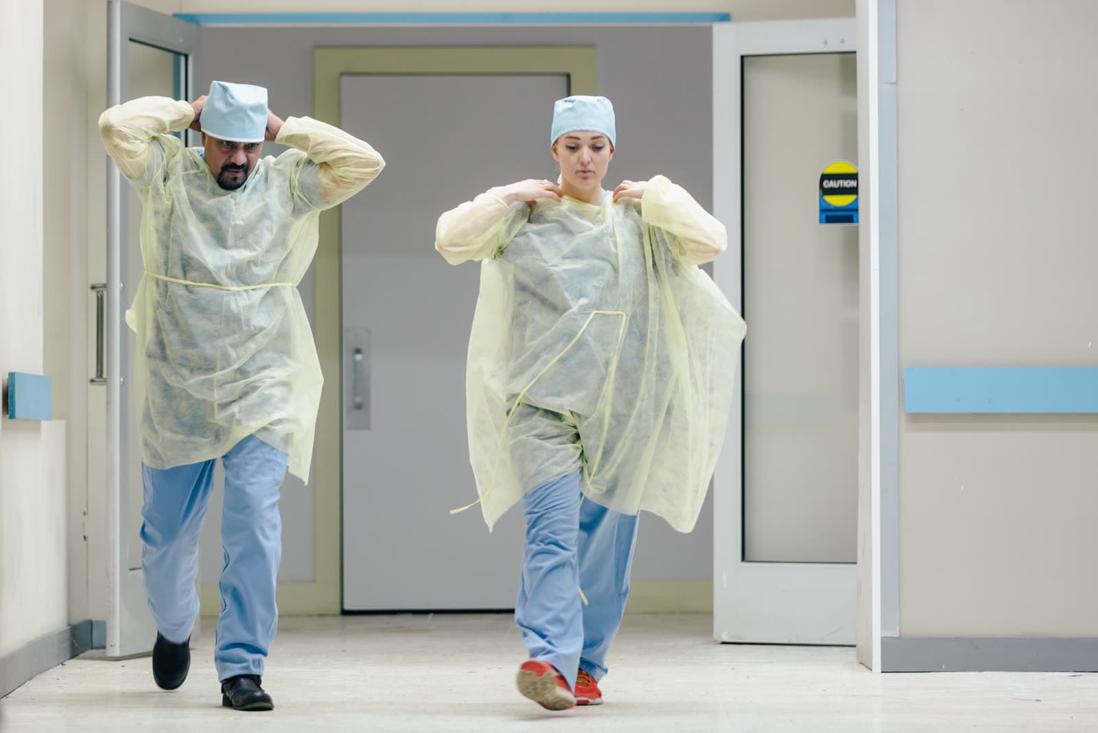 Zwei Ärzte in Schutzkitteln gehen durch einen Krankenhausflur